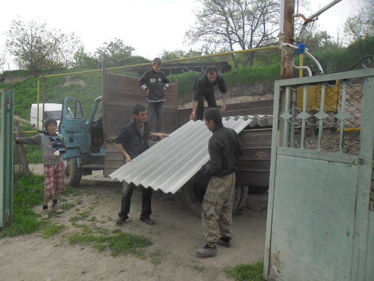 Razmik working on repairing his barn with his family.