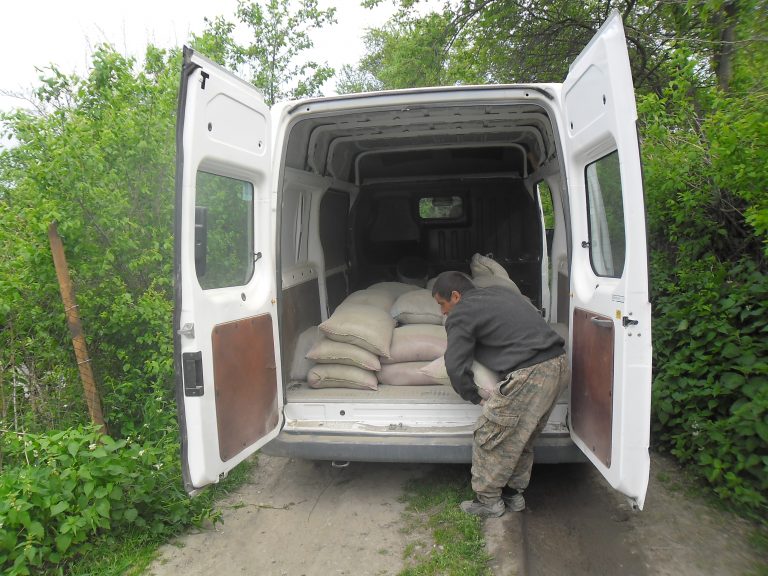 Araik moving bags of cement he will use to renovate his barn.