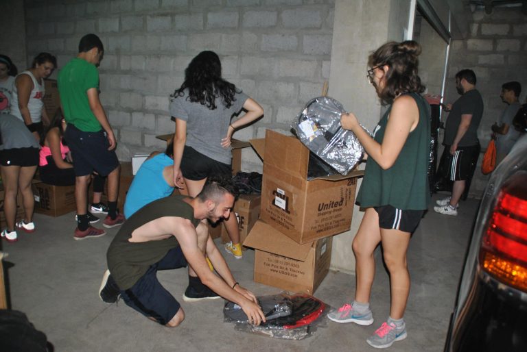 SERVICE Armenia volunteers prepare the backpacks for the children.