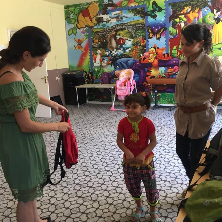 Children receiving their new backpacks.