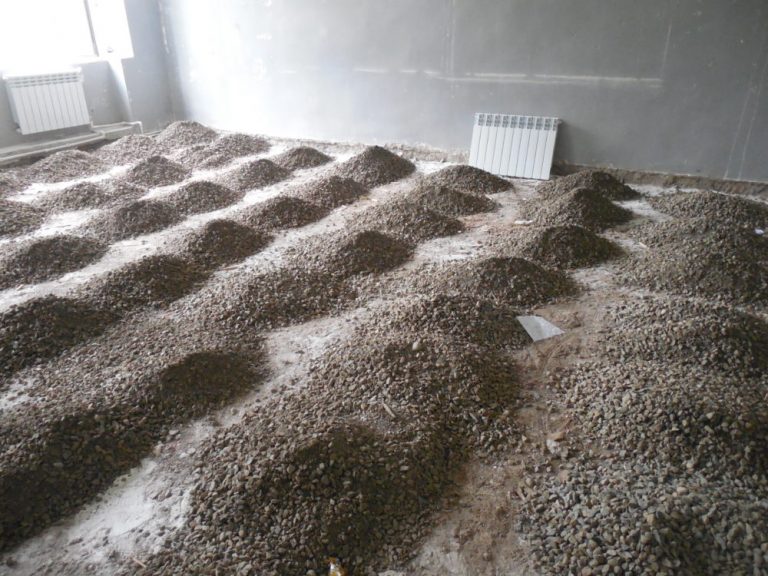 Crushed stone is spread to level the floor beneath the subfloor.