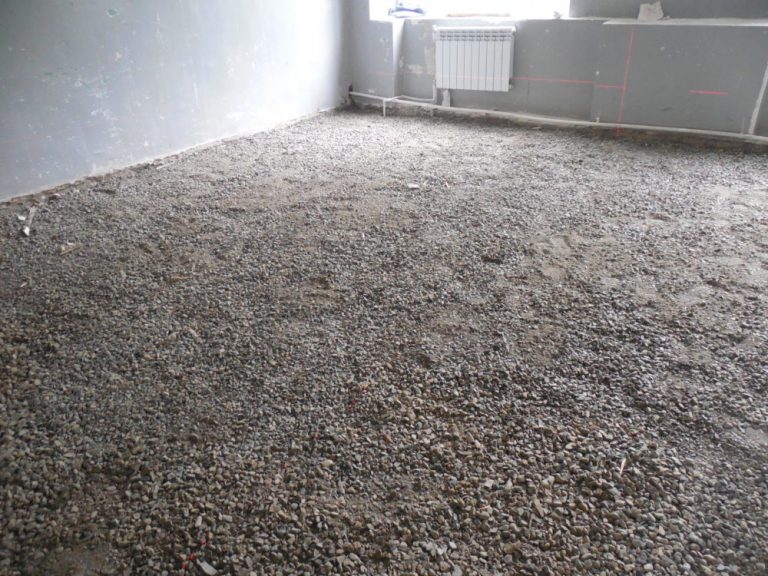 Crushed stone is spread to level the floor beneath the subfloor.