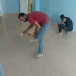 The construction crew applying a finish coat of sealant to the hallway floors at the Zorakan School.