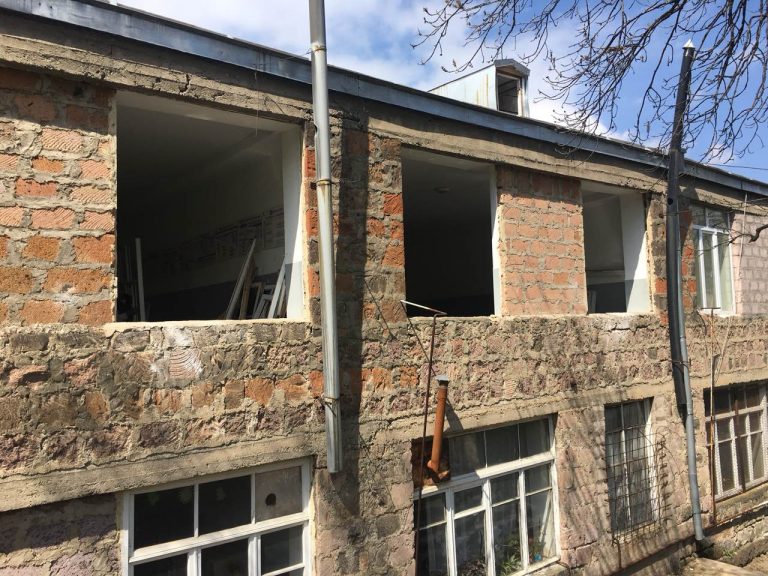 Main entrance to the school with broken and dangerous glass blocks.