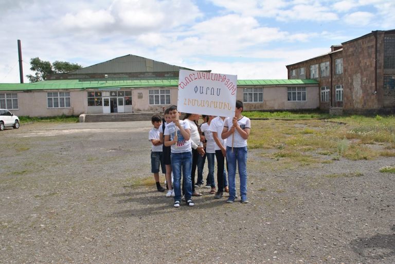 Children who attend the Ljashen Village School holding up a sign thanking The Paros Foundation.