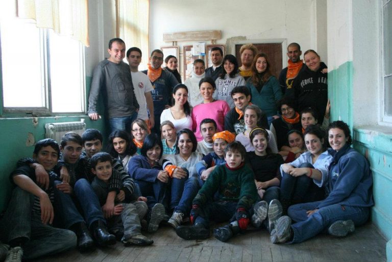 Mentors and the students take a group photo following a community service day where they painted a kindergarten together.
