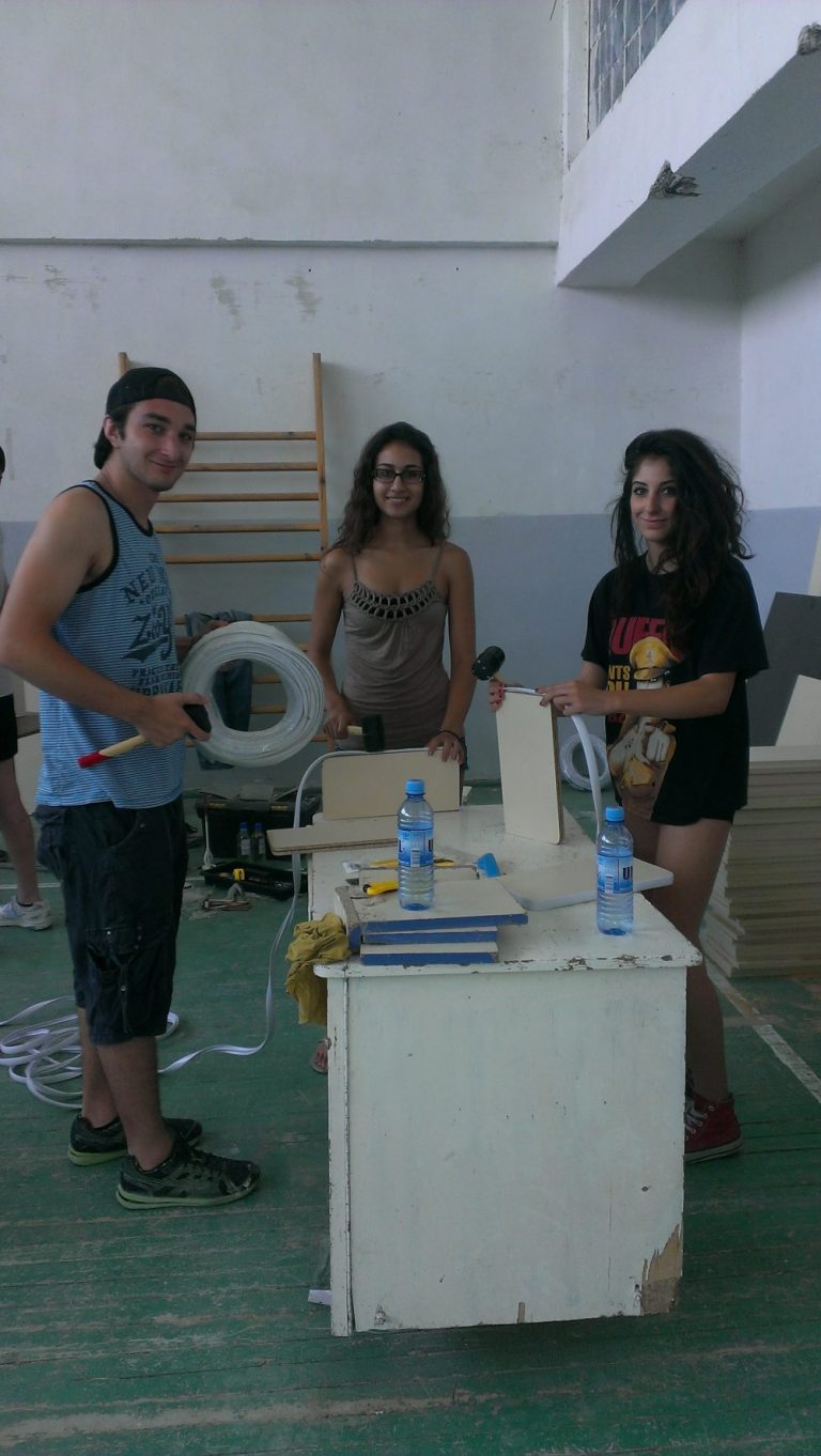 SEVICE Armenia 2013 participants working on placing new edging on refurbished desk parts.