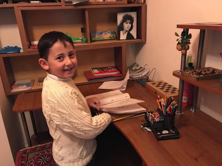 Armen doing his homework in his new apartment.
