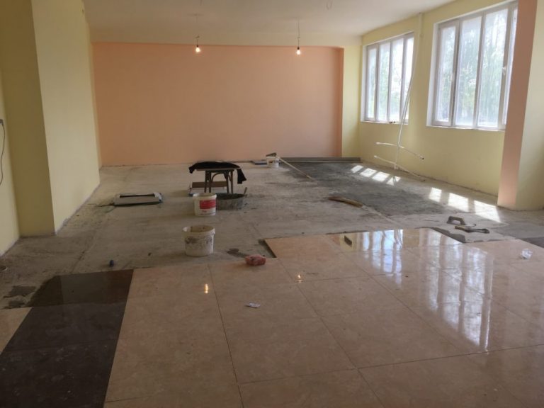Floor tile being installed at the Hatsik School auditorium.