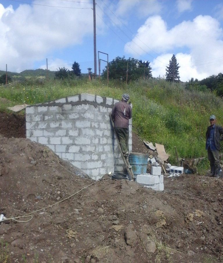 Local workers building the pump house.