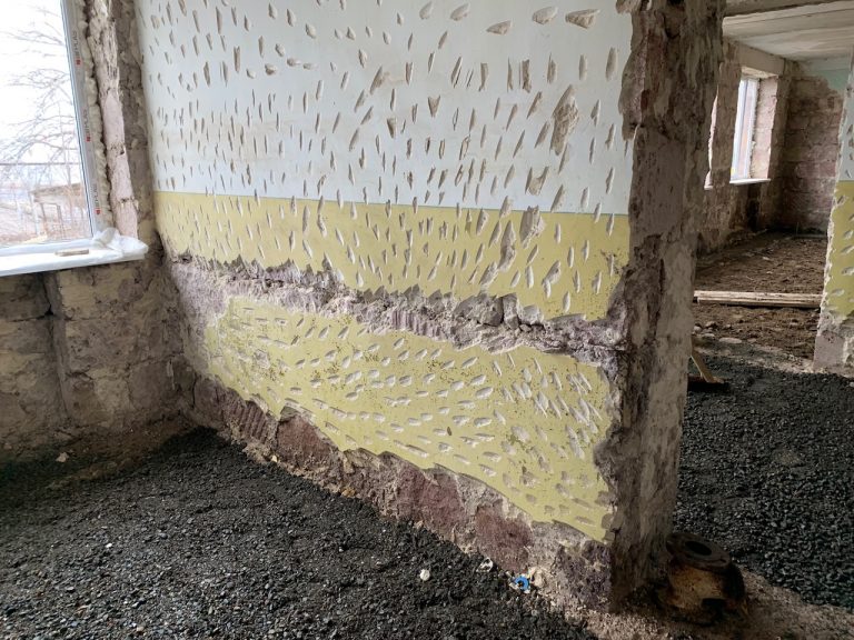 The existing plaster is chipped in order to provide proper adhesion for the new plaster on the walls.