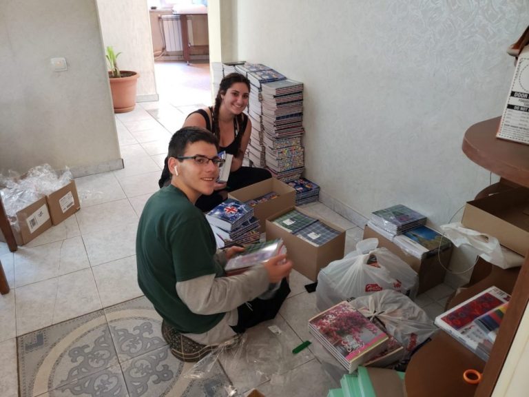SERVICE Armenia 2019 participants assembling backpacks for the children at 
Debi Arach.