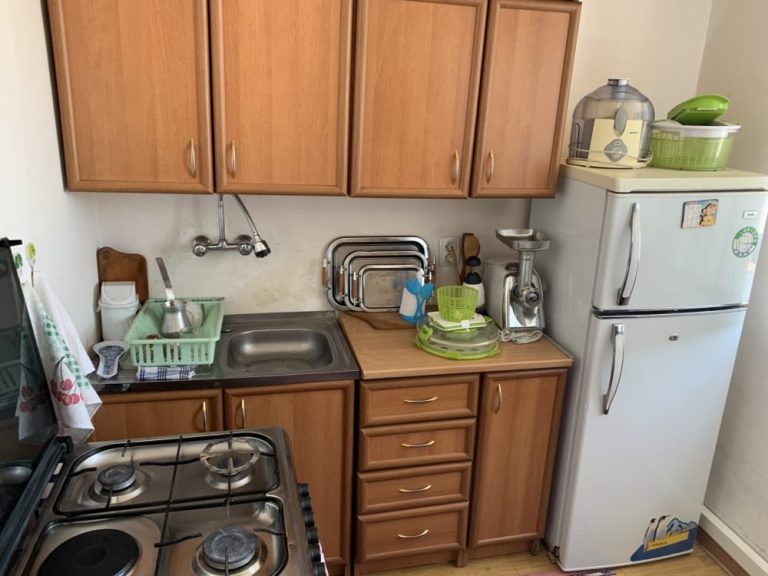 The Chakhalyan's new home comes with appliances including a stove and a refrigerator.