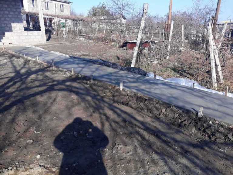A new concrete sidewalk is poured to lead to Suren's home.
