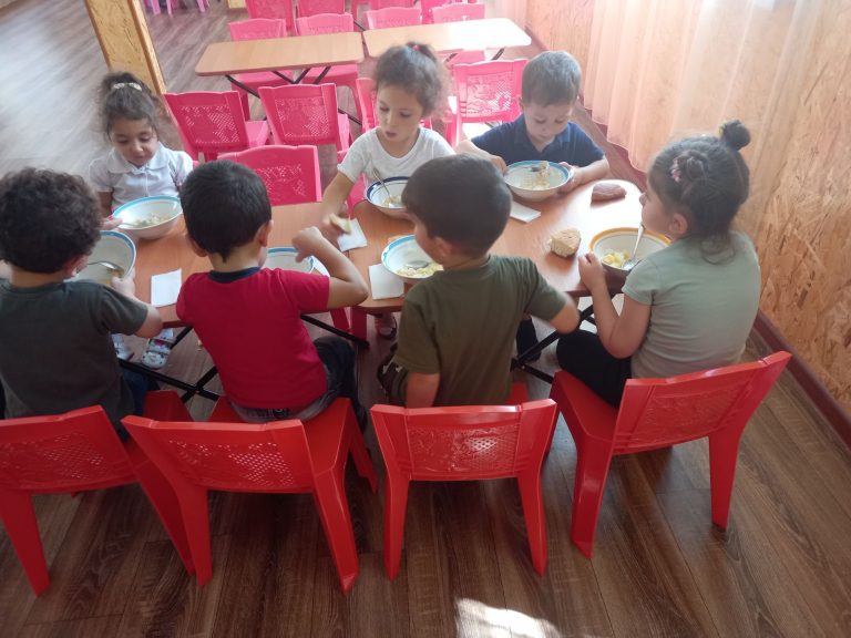 Children eating a warm and nutritious meal at the Yegheknadzor Kindergarten.