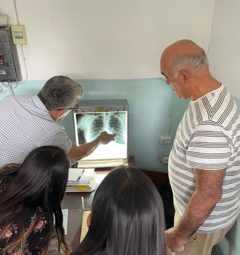 Dr. Deramerian, leader of the MedAid Medical mission views the poor images from the Nor Hachen x-ray machine.