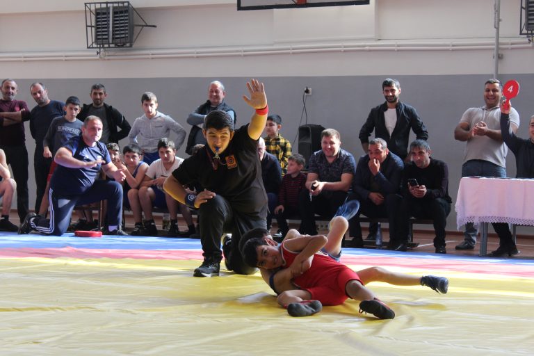 Two children in the middle of a wrestling match.