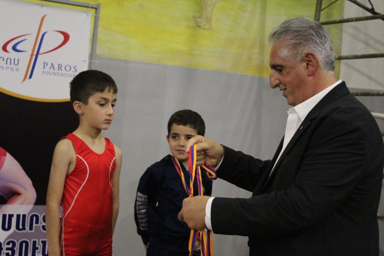 A participant is awarded a medal by Peter Abajian, The Paros Foundation Executive Director.